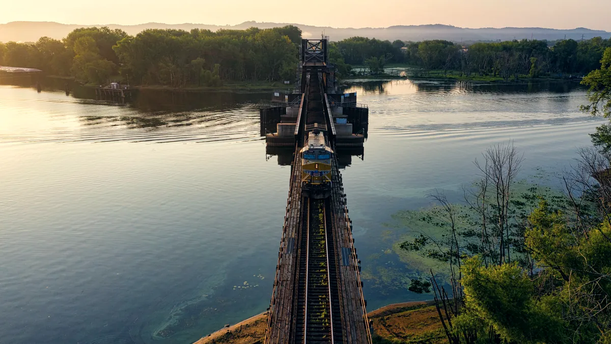 Ponte ferroviária de treliça metálica atravessando um rio ao entardecer