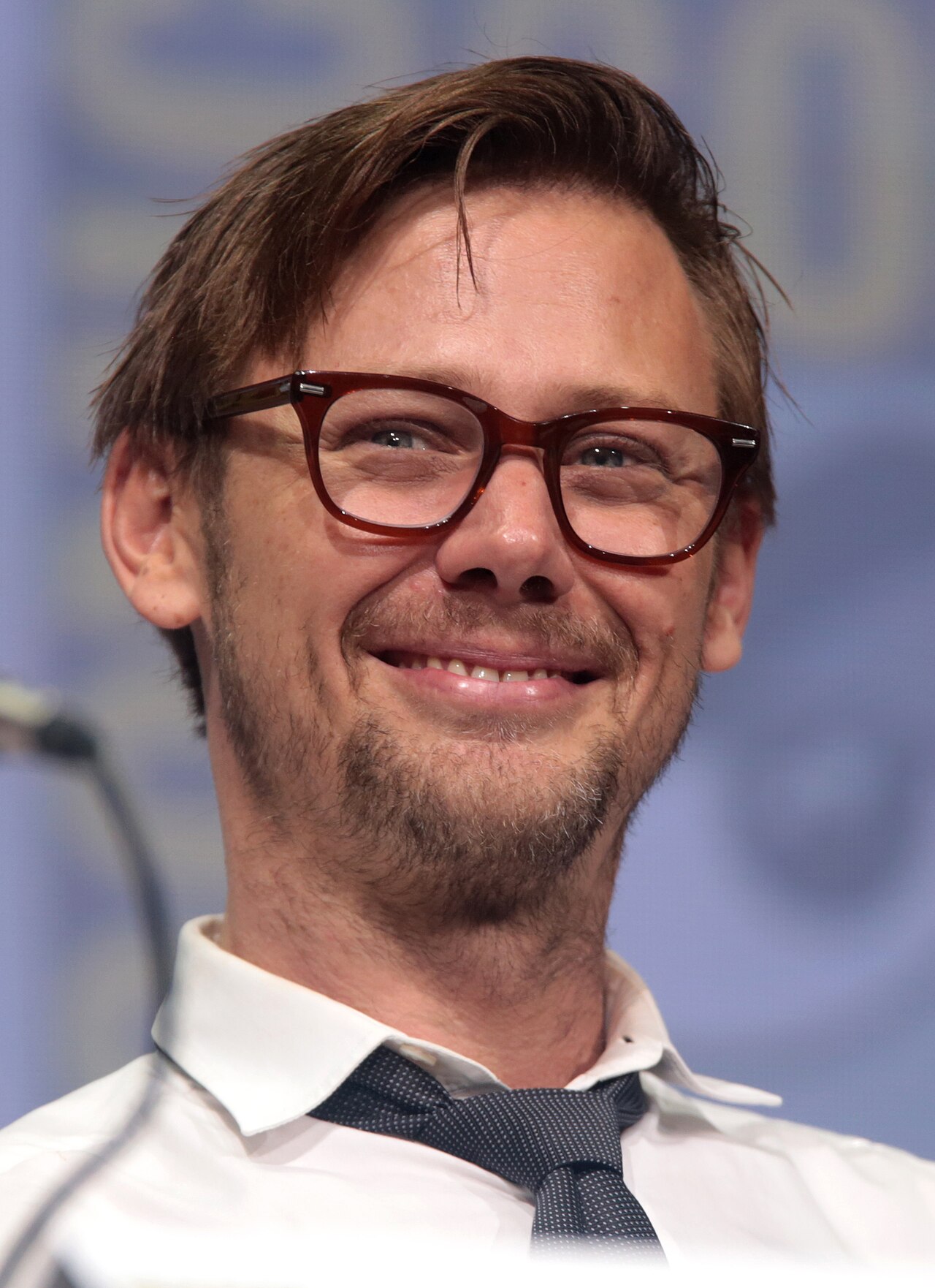 Jimmi Simpson, de barba e cabelo curto, fala ao microfone na Comic-Con de San Diego