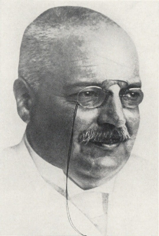 Fotografia antiga do psiquiatra Alois Alzheimer, de bigode, cabelo curto e óculos, em retrato de busto