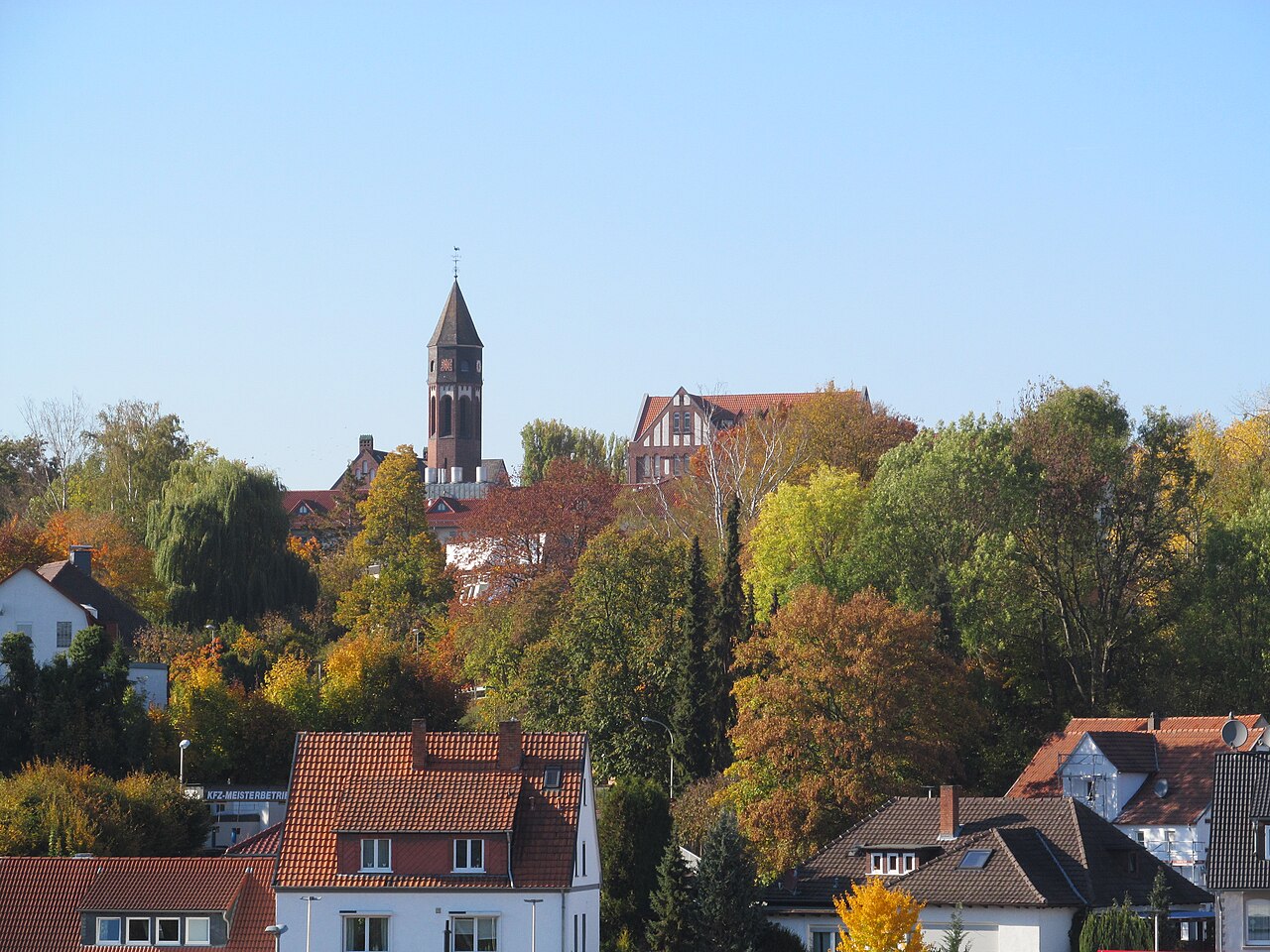 Vista da cidade de Treysa com a torre de tijolos da igreja de Hephata acima das árvores de outono