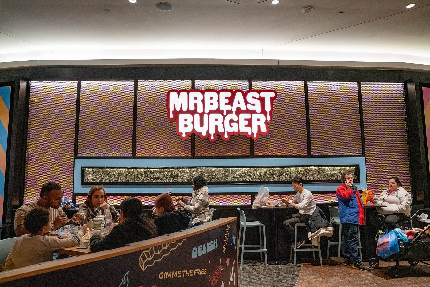 Balcão da MrBeast Burger em praça de alimentação de shopping, com clientes sentados às mesas