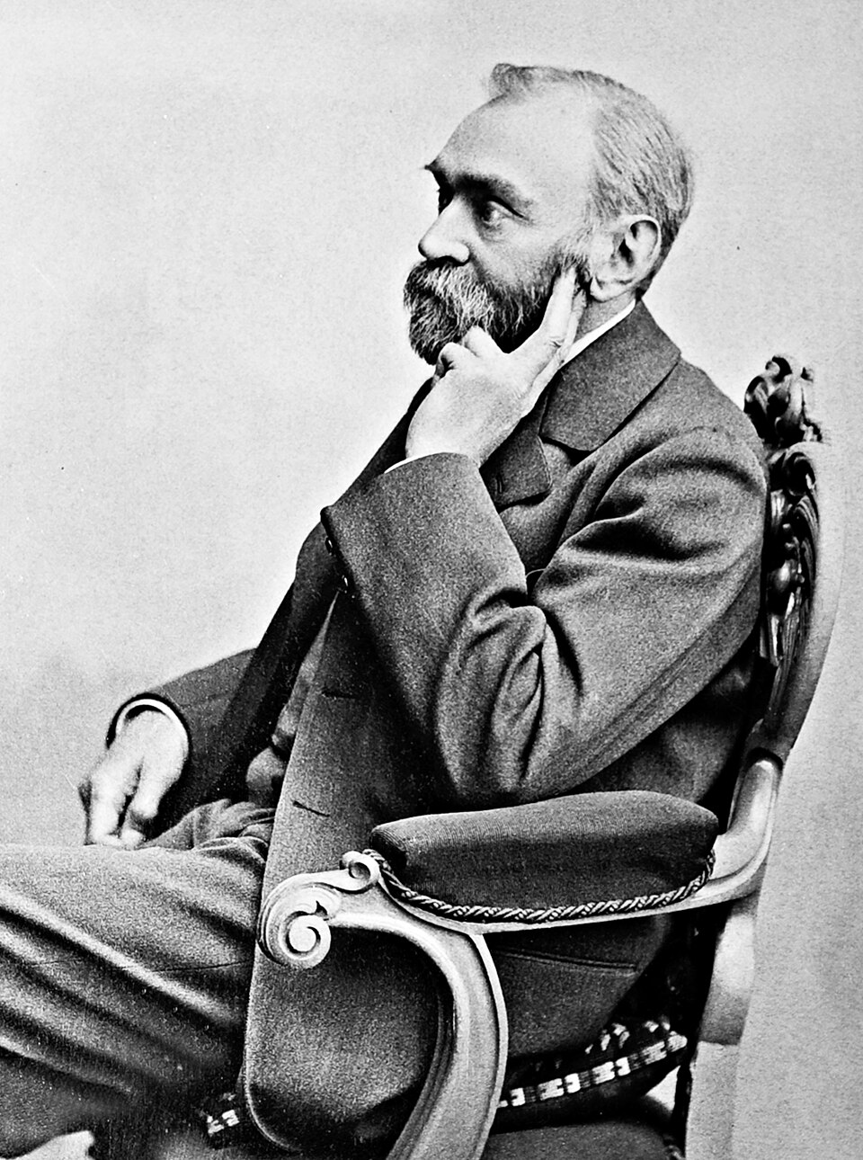 Retrato fotográfico de Alfred Nobel, homem de meia-idade com barba e bigode, de terno escuro